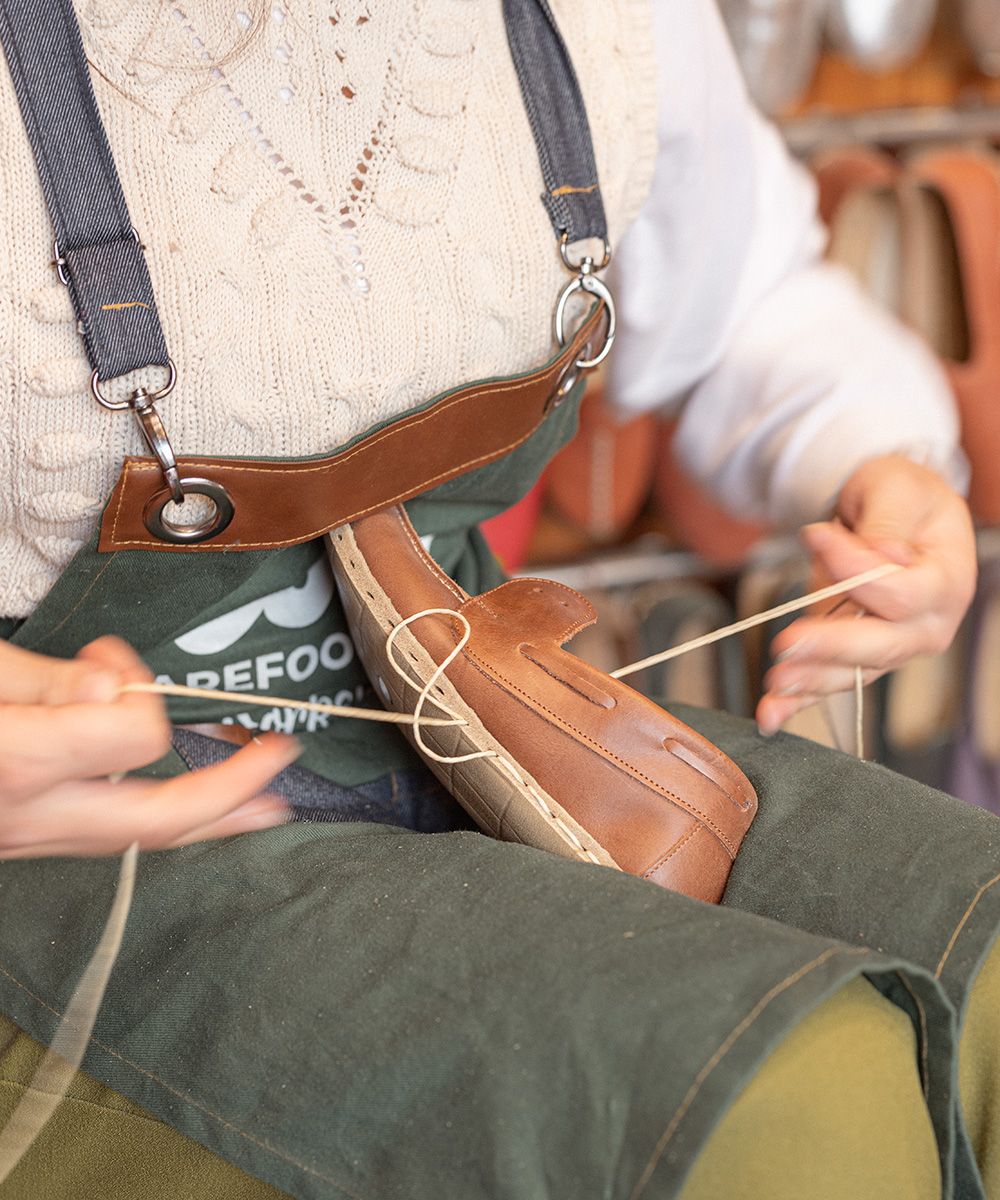 Hand-stitching a leather moccasin with waxed thread at the Ede atelier